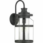 The one-light large wall lantern in the Haslett Collection features a design with intersecting linear details that surrounds clear seeded glass and finished in Black. Coastal-inspired frame is suitable to complement architecture with Farmhouse flair.