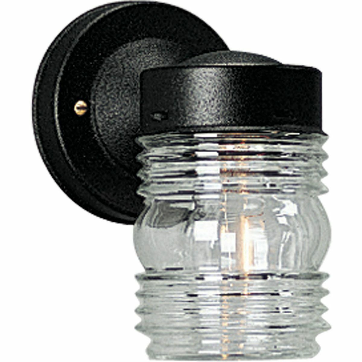 An outdoor injelly jar in utility wall lantern featuring a black powder-coated finish and clear marine glass. The fixture is wet location listed and ideal for outdoor spaces. The glass shape is a reminder of the old-fashioned jelly jars.